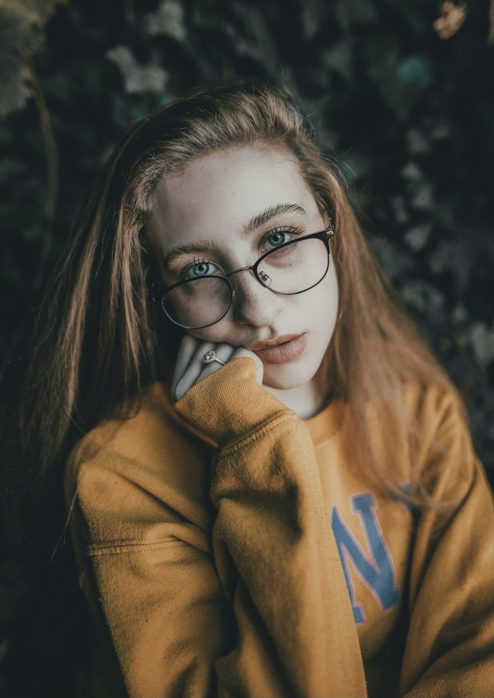 woman in brown hoodie wearing black framed eyeglasses