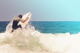 man in black wetsuit surfing on sea waves during daytime