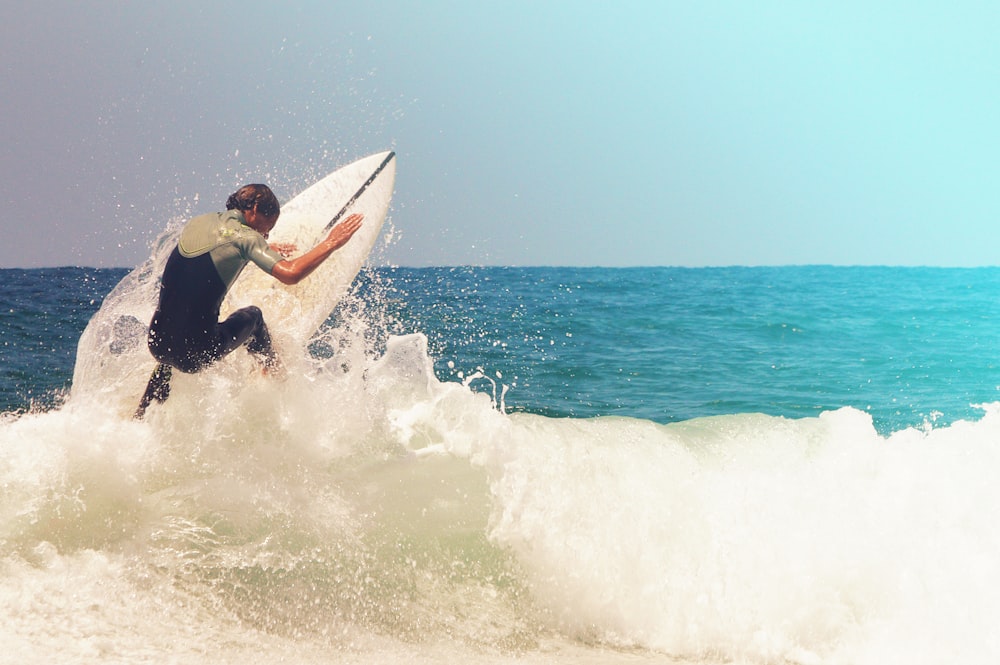 man in black wetsuit surfing on sea waves during daytime