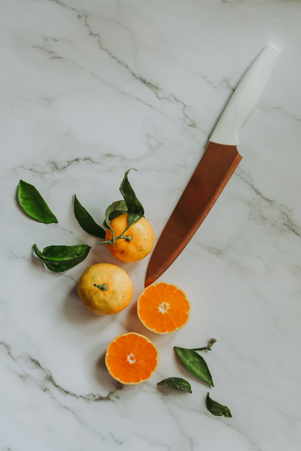 갈색 손잡이 칼 옆에 얇게 썬 오렌지 과일