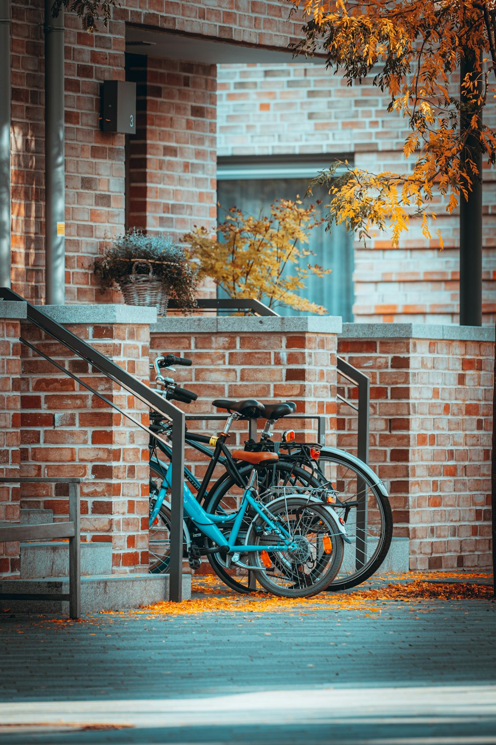 blue city bike parked beside brown brick wall