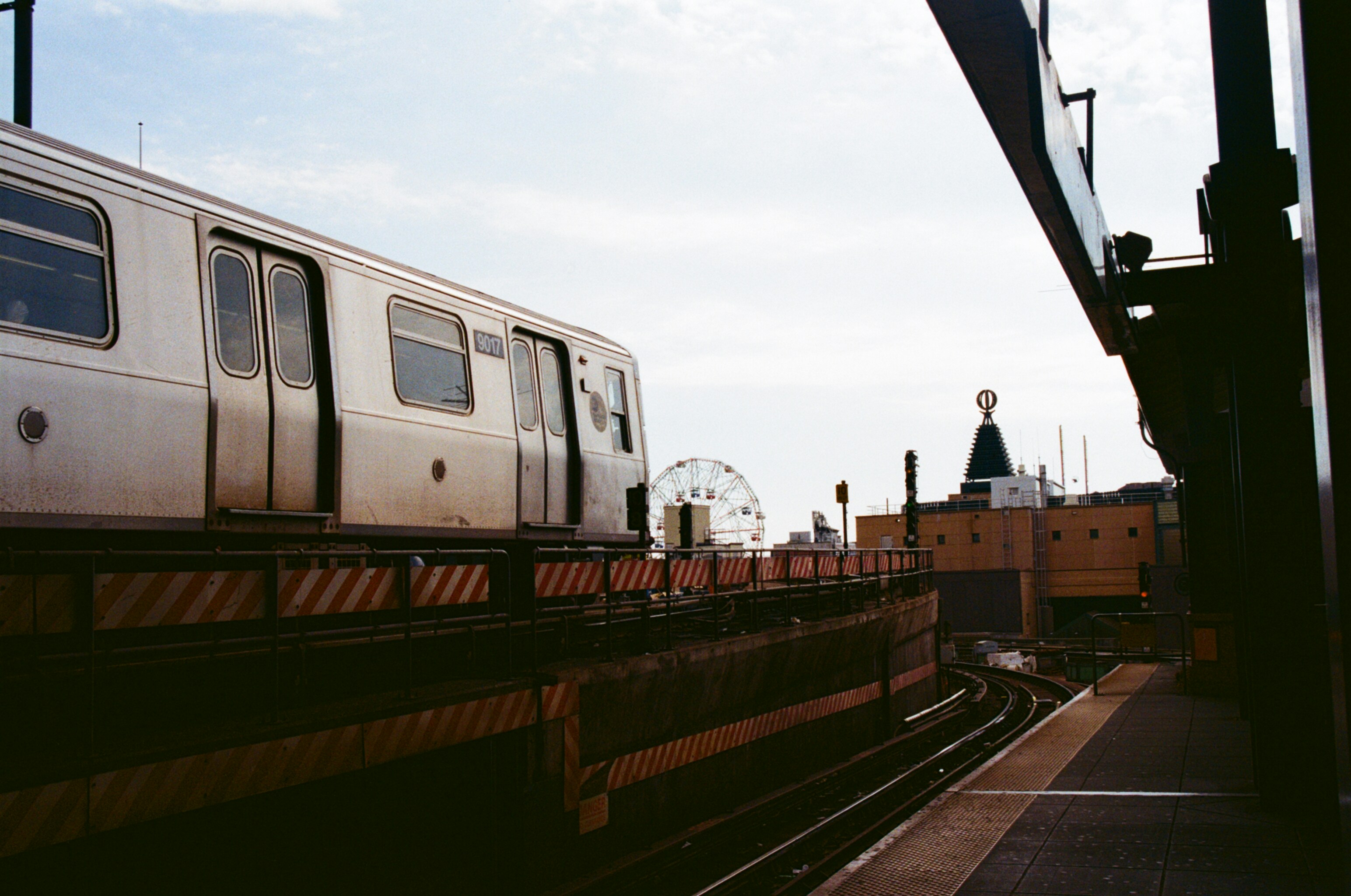man in black jacket standing on train rail during daytime