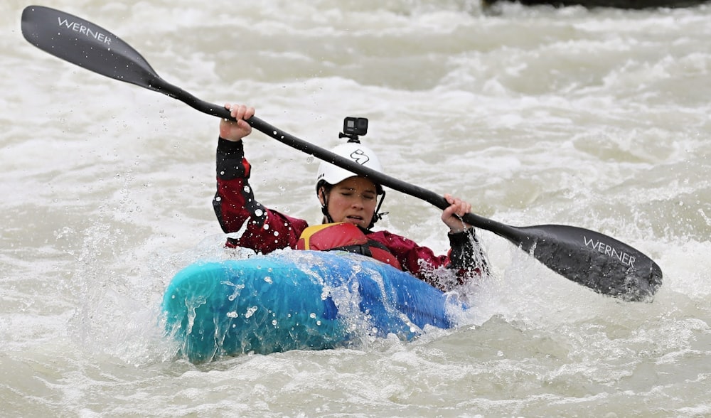 man in red shirt riding red kayak on water during daytime