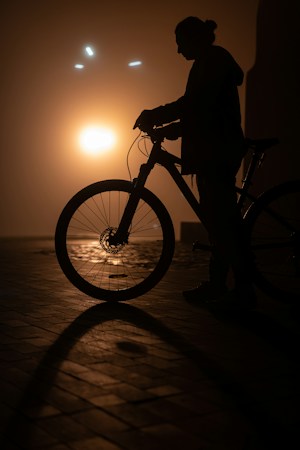 Silhouette of a person riding a bicycle at dusk, similar to the early evening check-in time for the event