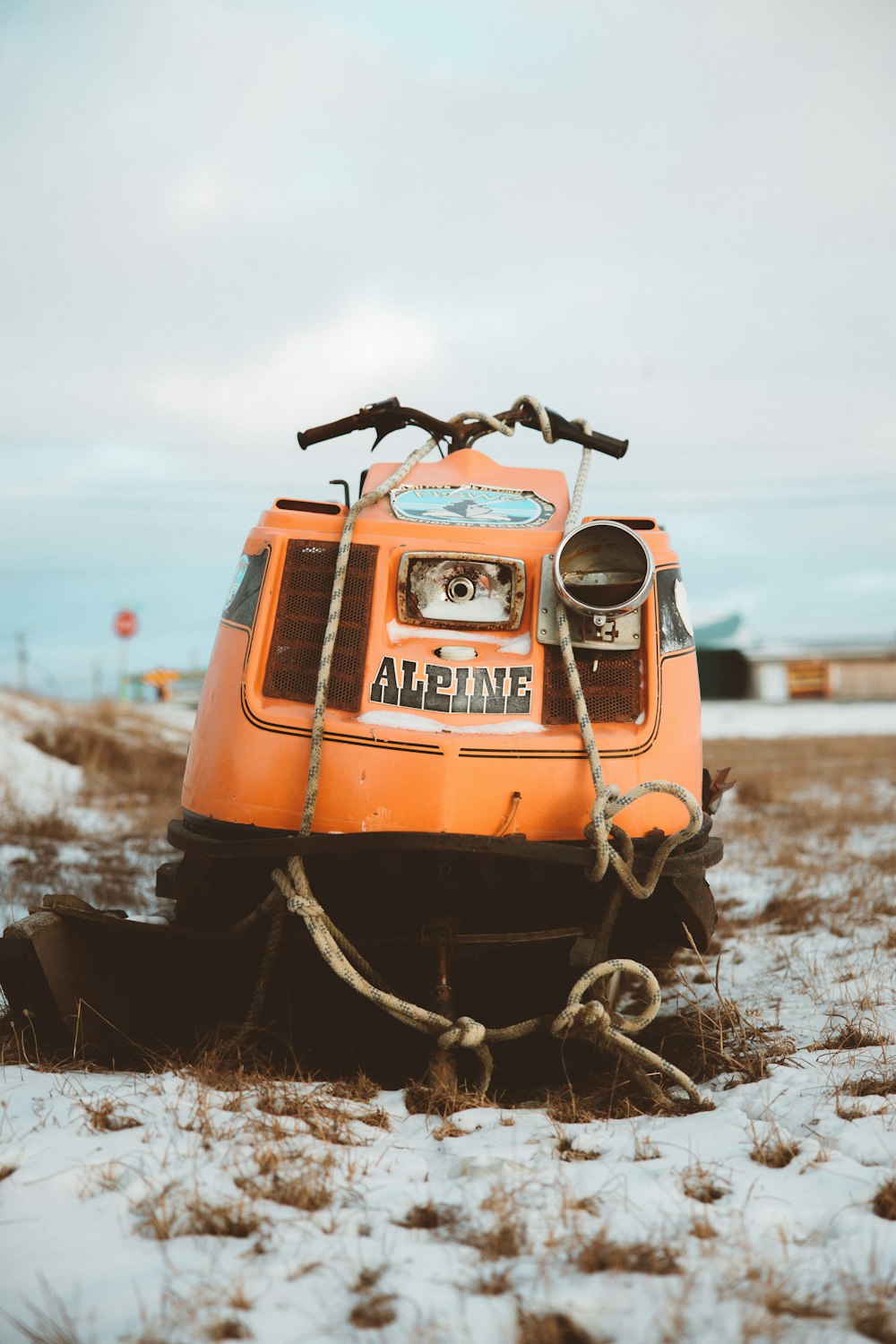 orange and black car on snow covered ground during daytime