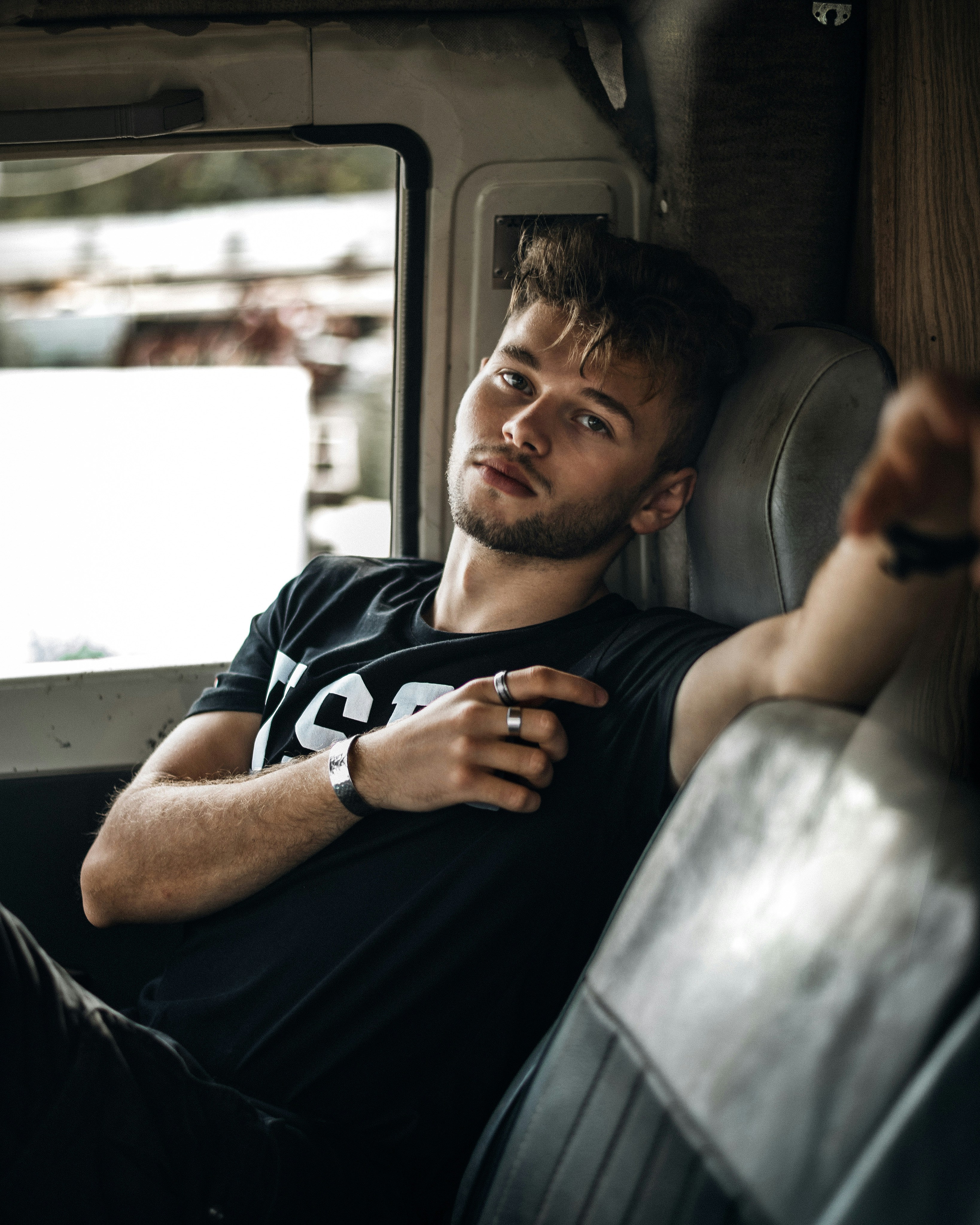 man in black crew neck t-shirt sitting on car seat
