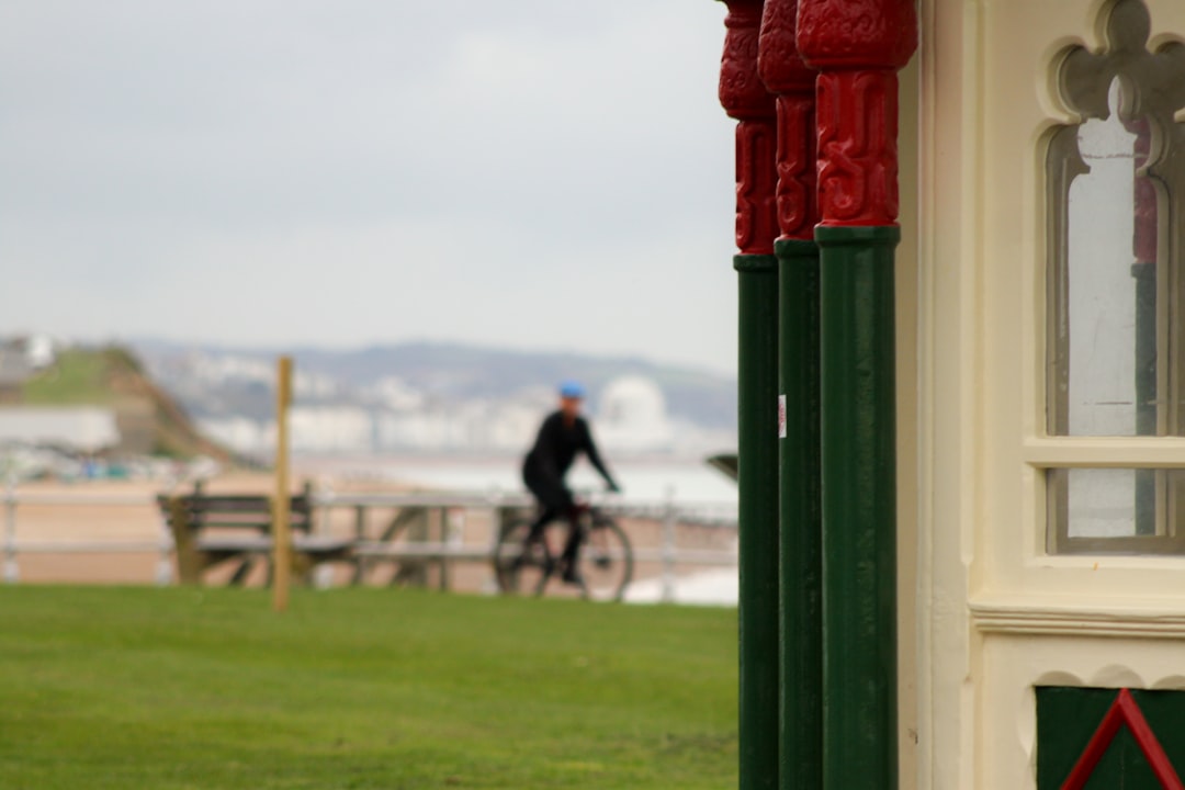 man in black shirt riding bicycle on green grass field during daytime