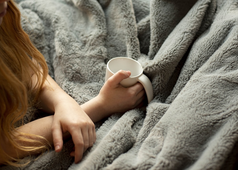 woman holding white ceramic mug