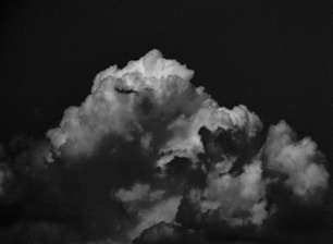 A dramatic black-and-white photo of a nuclear mushroom cloud rising over a barren landscape.