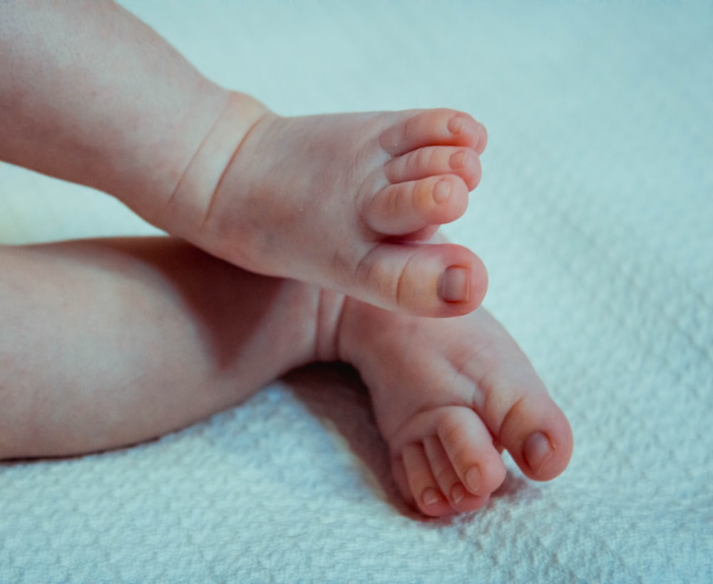 babys feet on pink textile