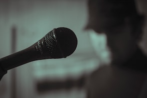 Close-up of Echovibe tuning a vintage microphone in a cozy studio setting