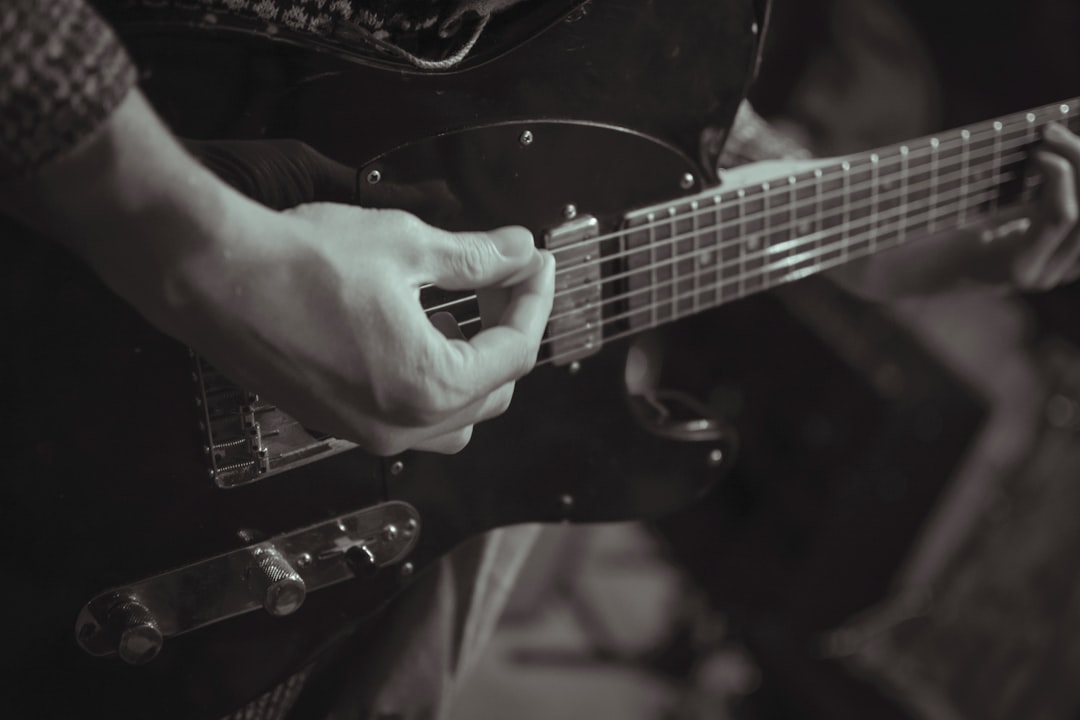 person playing black electric guitar