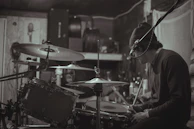 Sonoravibe smiling while recording vocals in a cozy, dimly lit studio.