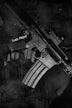 black and white rifle on black textile