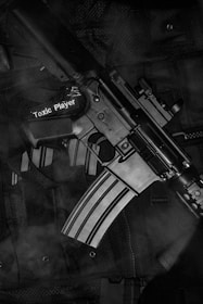 black and white rifle on black textile