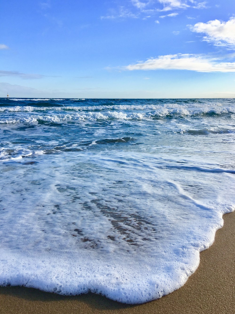 ocean waves crashing on shore during daytime