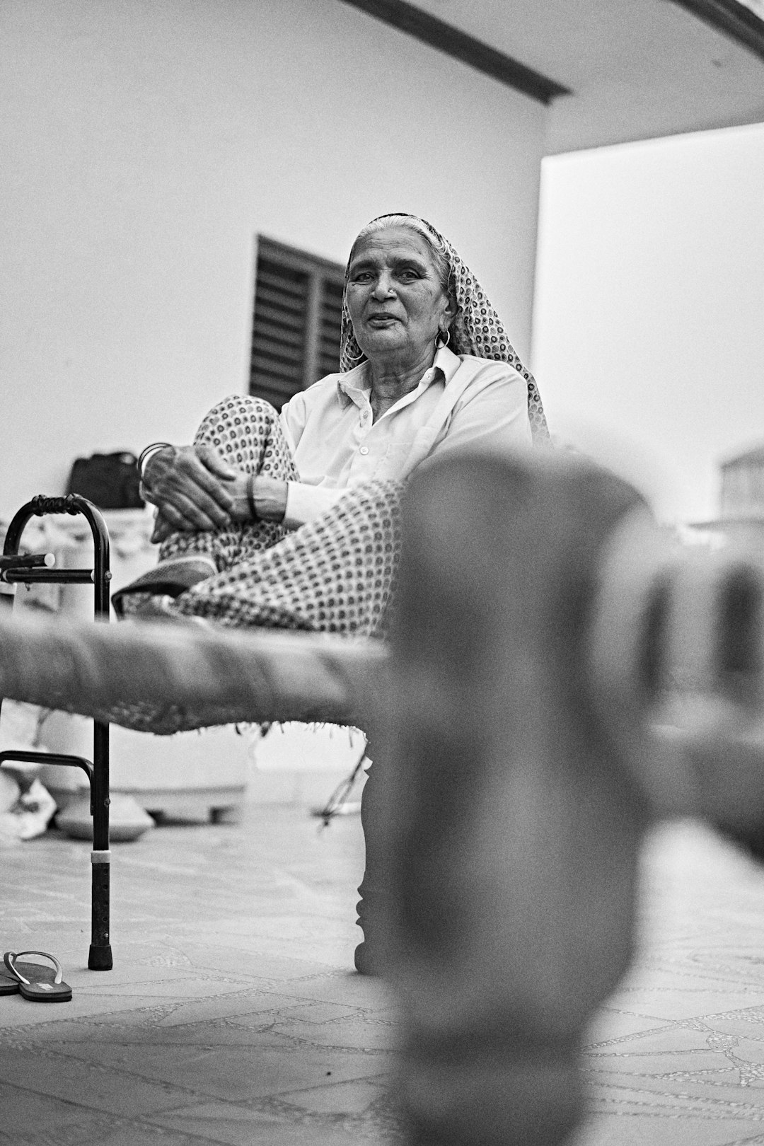  grayscale photo of woman sitting on bench bedstead bunk cot