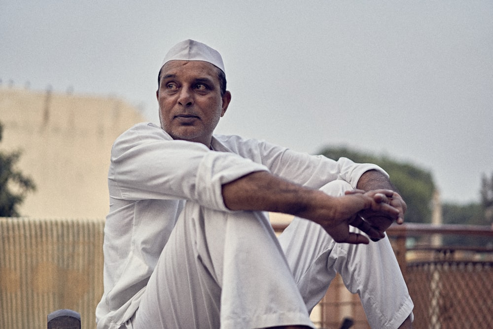 man in white thobe holding black smartphone