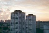 High-rise luxury flats overlooking a bustling cityscape at sunset.