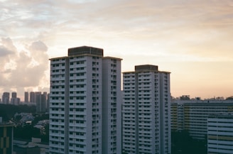 Modern high-rise residential building in Doha skyline at sunset.