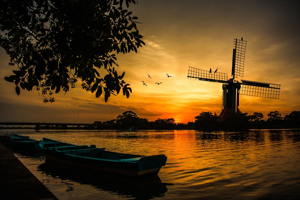 silhouette of boat on water during sunset