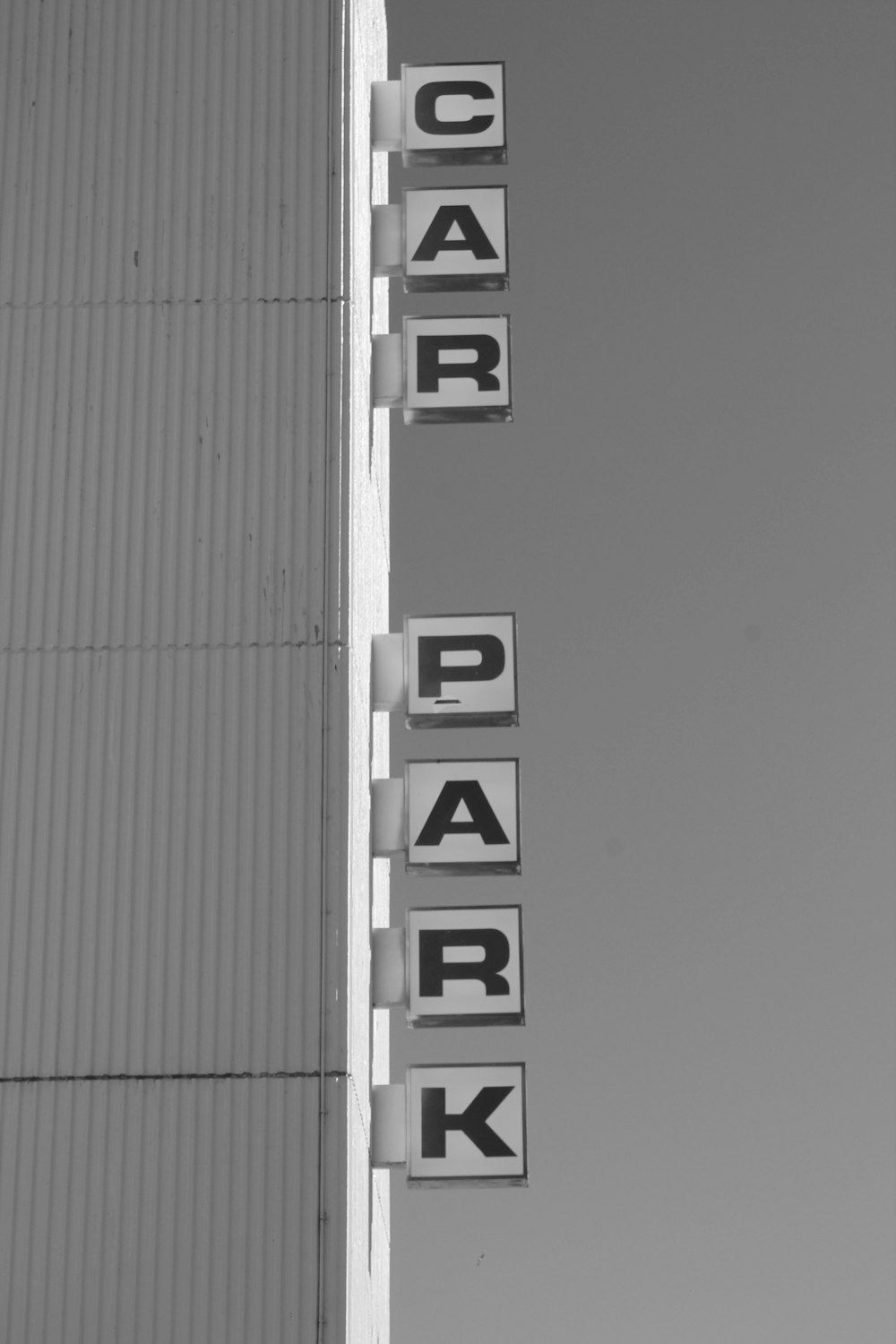 a black and white photo of a parking sign