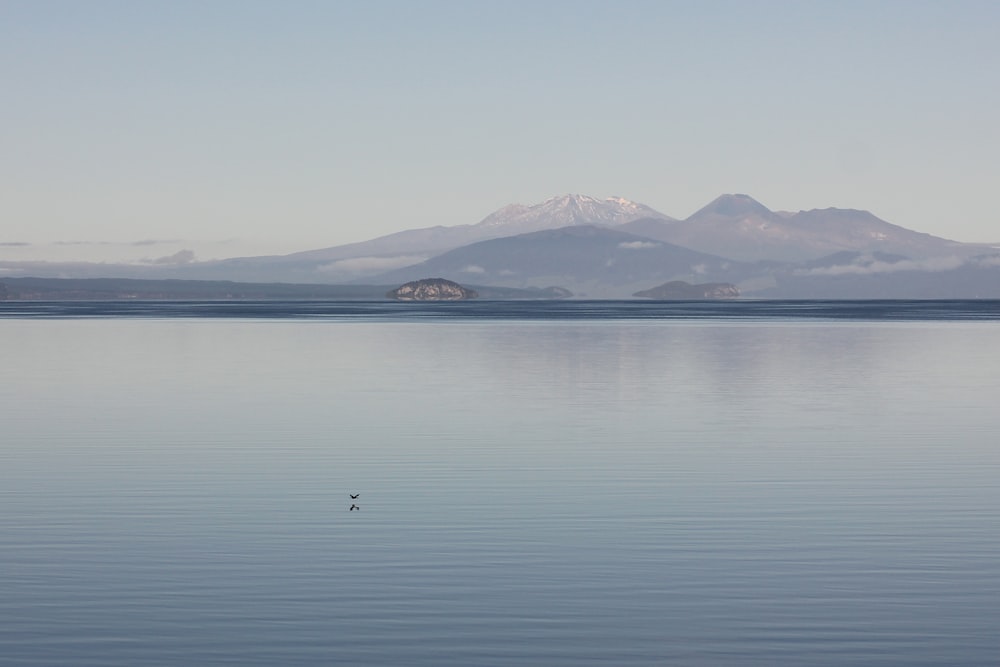 body of water near mountain during daytime