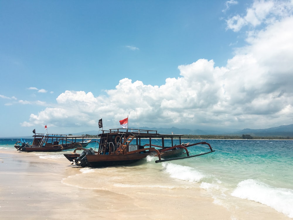 brown boat on sea shore during daytime