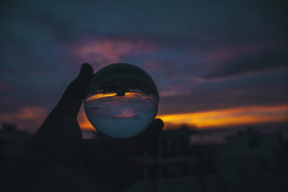 person holding clear glass ball