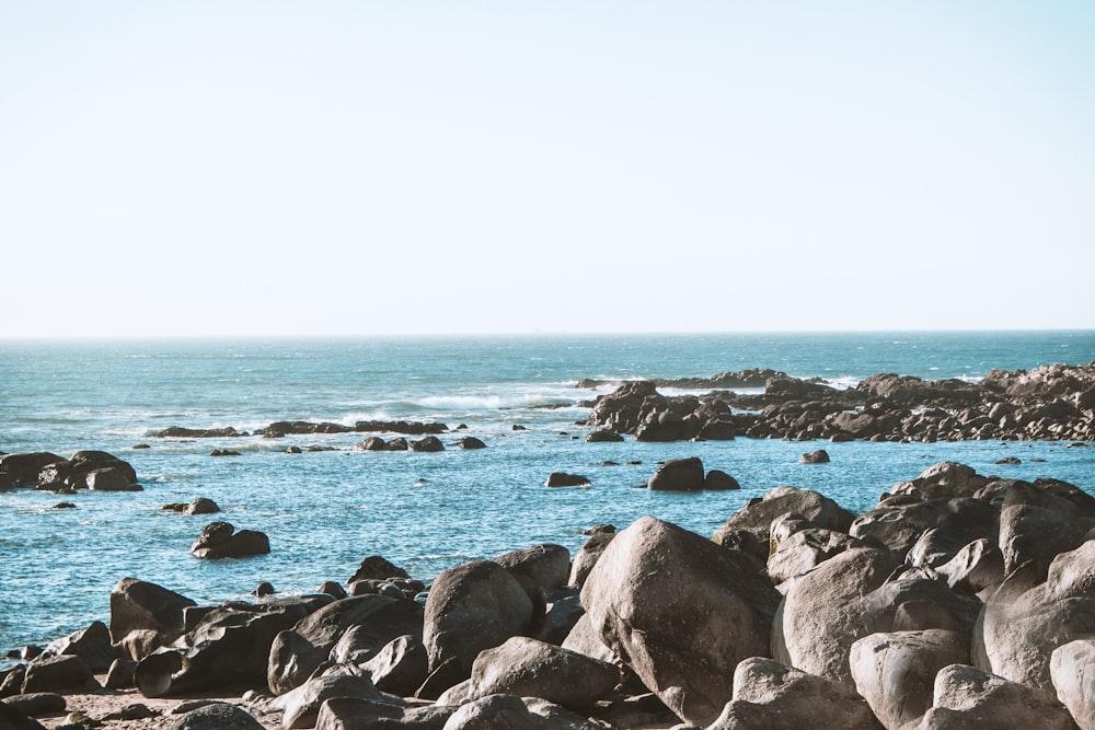 gray rocks on sea shore during daytime