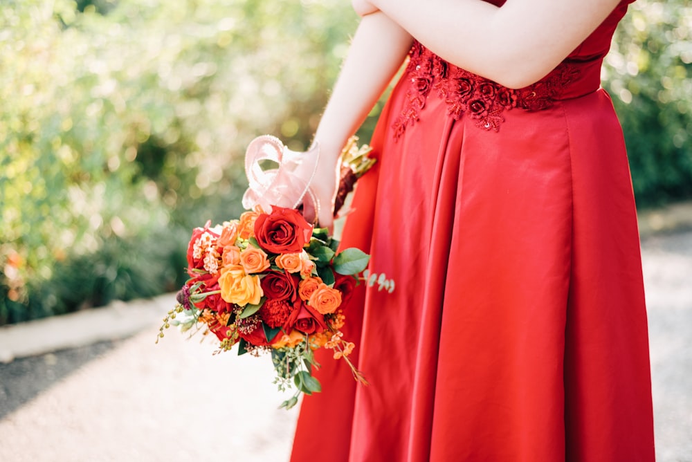 Foto Mujer en vestido rojo con ramo de rosas rojas Imagen Ropa gratis en Unsplash