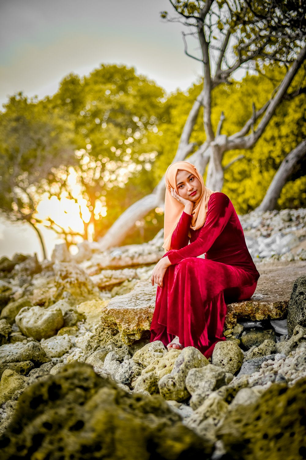 woman in red dress sitting on rock
