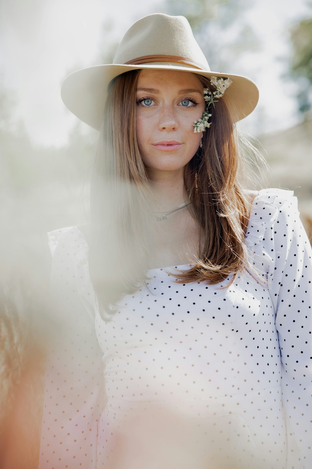 woman in white and red polka dot long sleeve shirt wearing brown hat