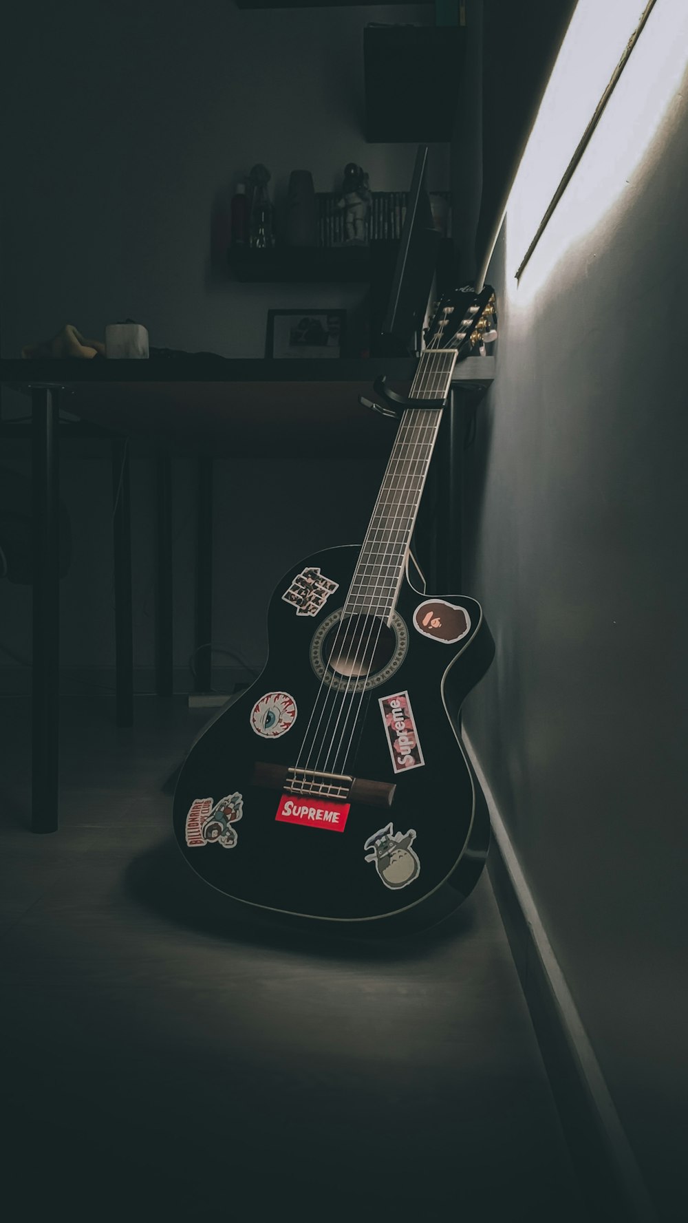 black acoustic guitar on black wall
