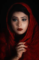 An intimate moment of a performer preparing backstage, wrapped in deep red fabric.
