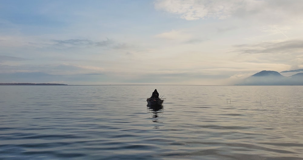 silhouette of person riding on boat on sea during daytime