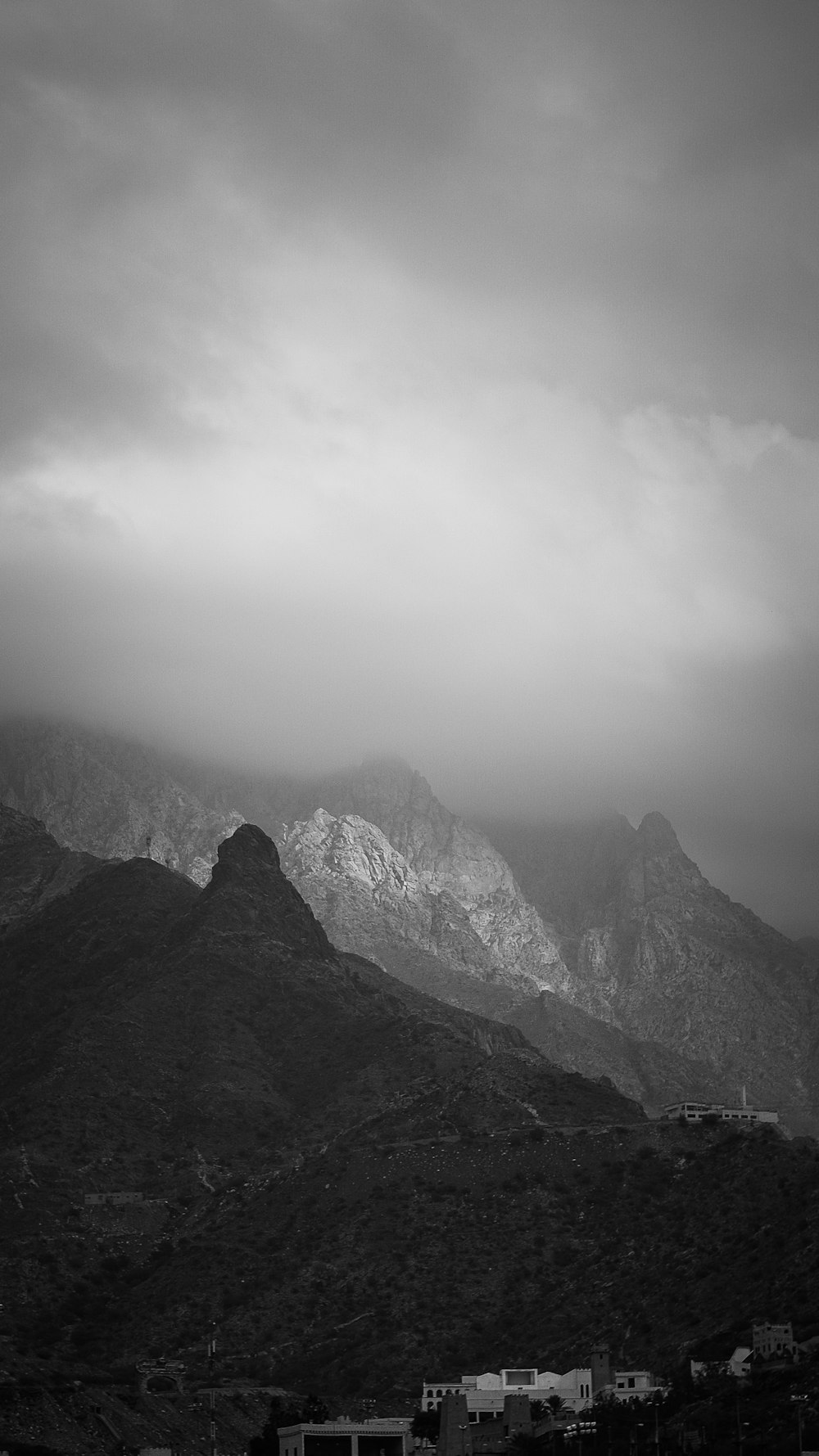 grayscale photo of mountains and clouds