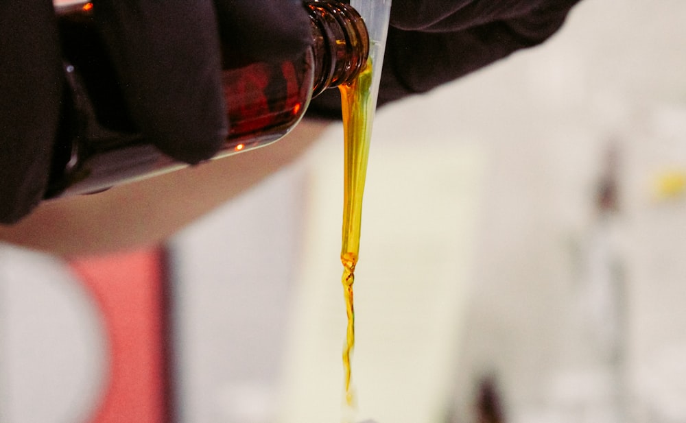 clear glass bottle with yellow liquid