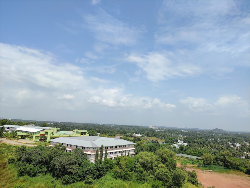 white concrete building near green trees under blue sky during daytime