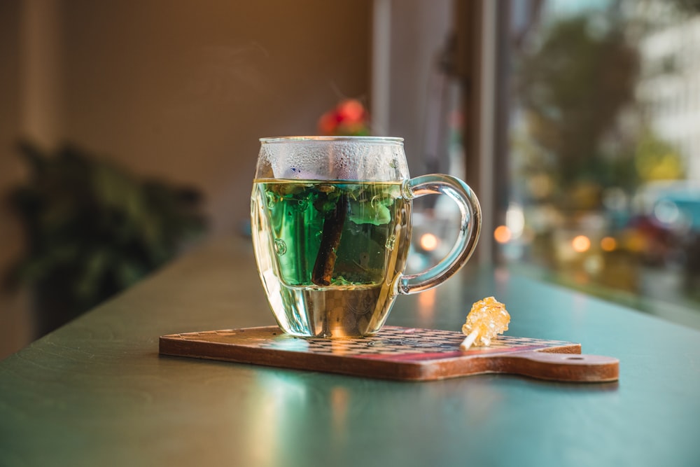 clear glass mug with green liquid inside