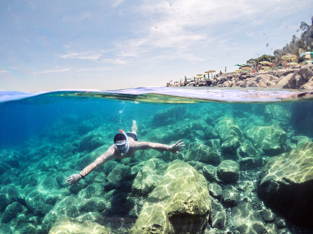 woman in black and white bikini swimming on sea during daytime