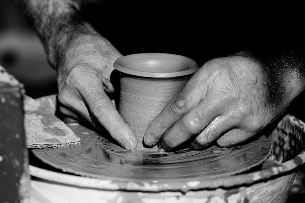 Photo en niveaux de gris d’une personne tenant une assiette ronde