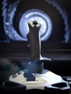 Close-up of a sleek aircraft joystick with vibrant lighting highlighting its controls.