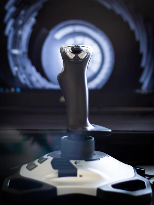 Close-up of a sleek aircraft joystick with vibrant lighting highlighting its controls.