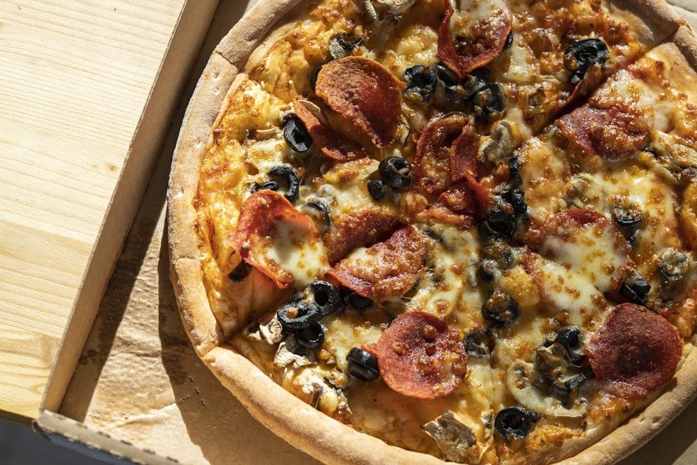 Pizza con pepperoni y queso sobre mesa de madera marrón