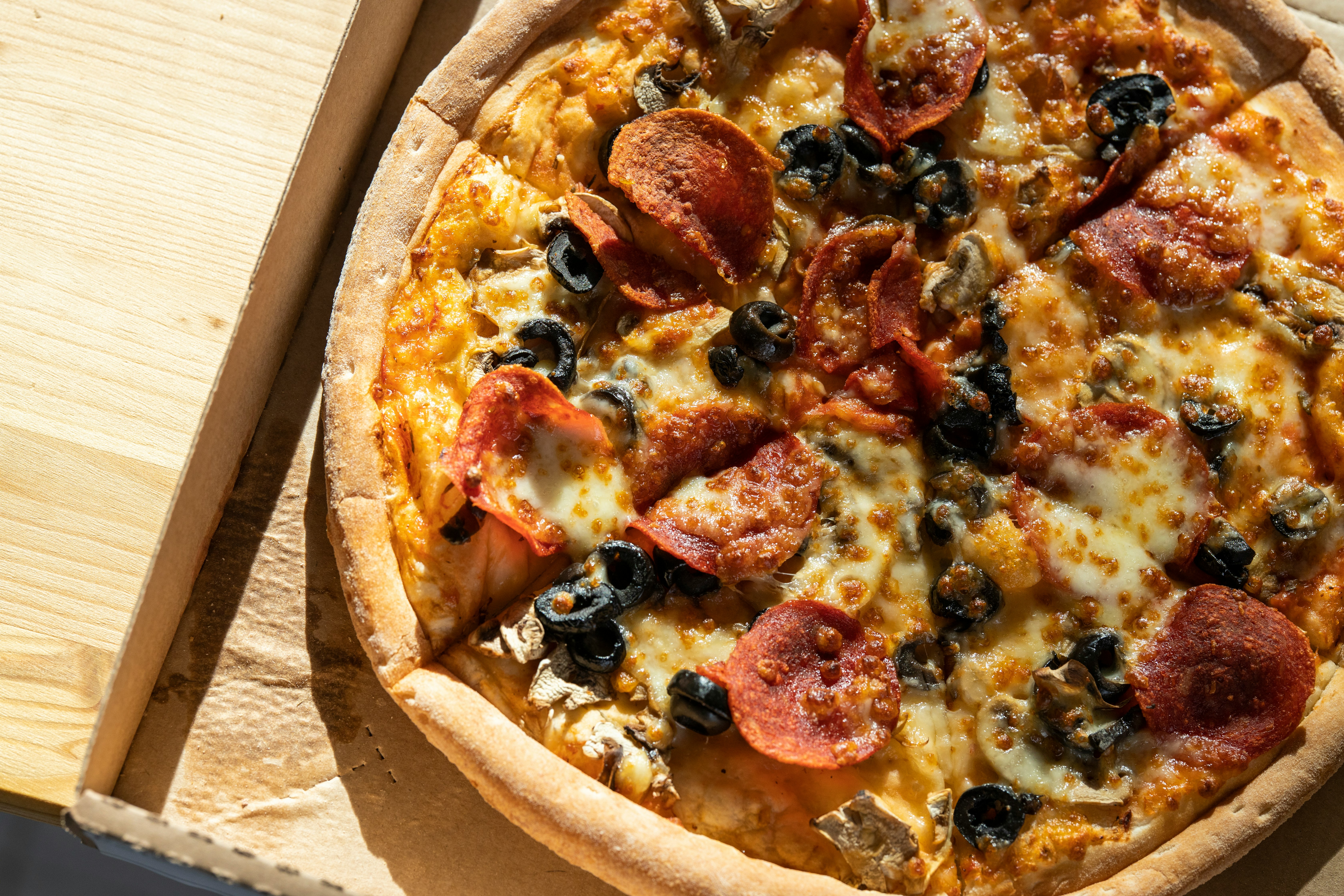 pizza with pepperoni and cheese on brown wooden table