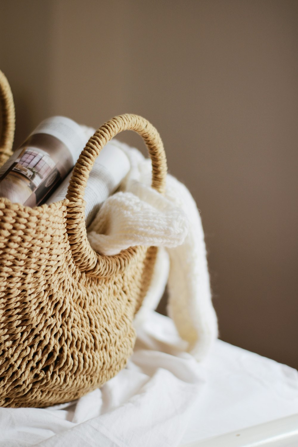 white and black labeled bottle on white knit textile