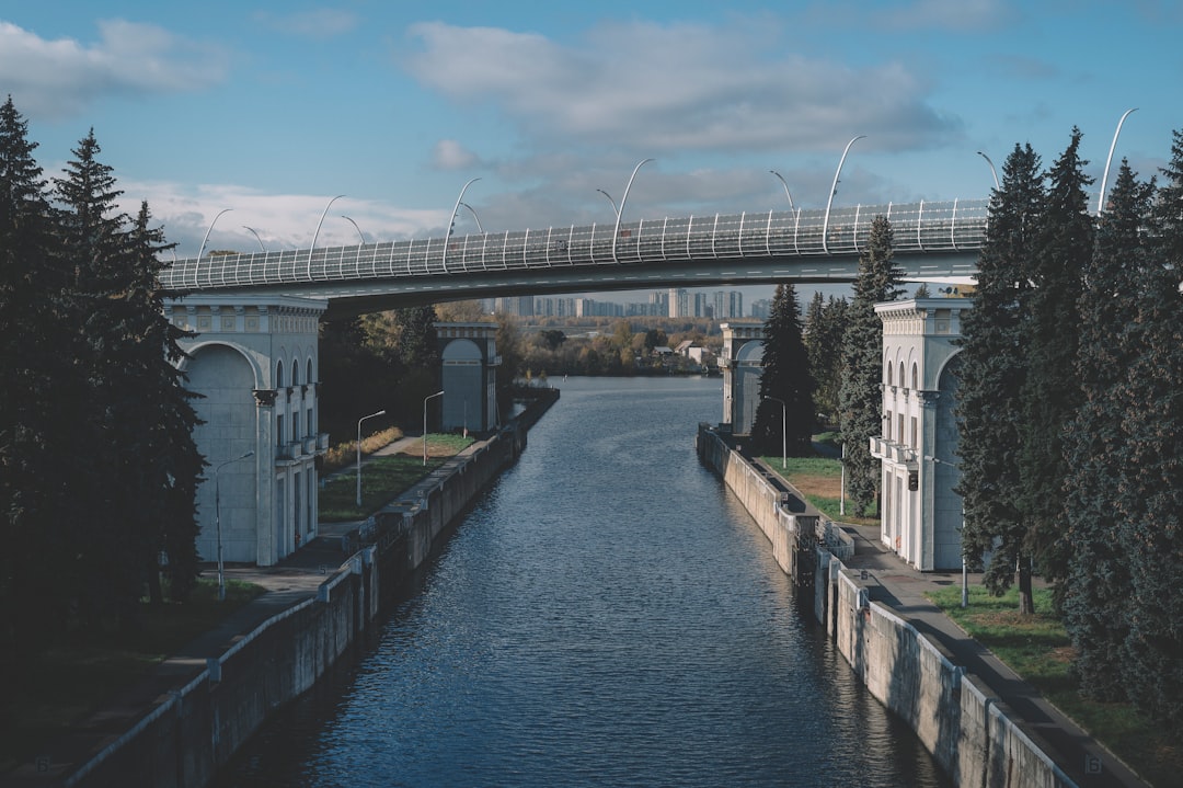 white concrete bridge over river under blue sky during daytime