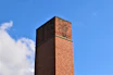 A friendly chimney sweep giving a thumbs-up next to a clean, smoke-free chimney top against a clear blue sky.