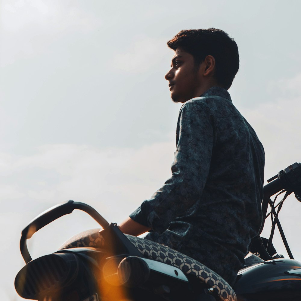 man in blue denim jacket riding on black and yellow motorcycle during daytime